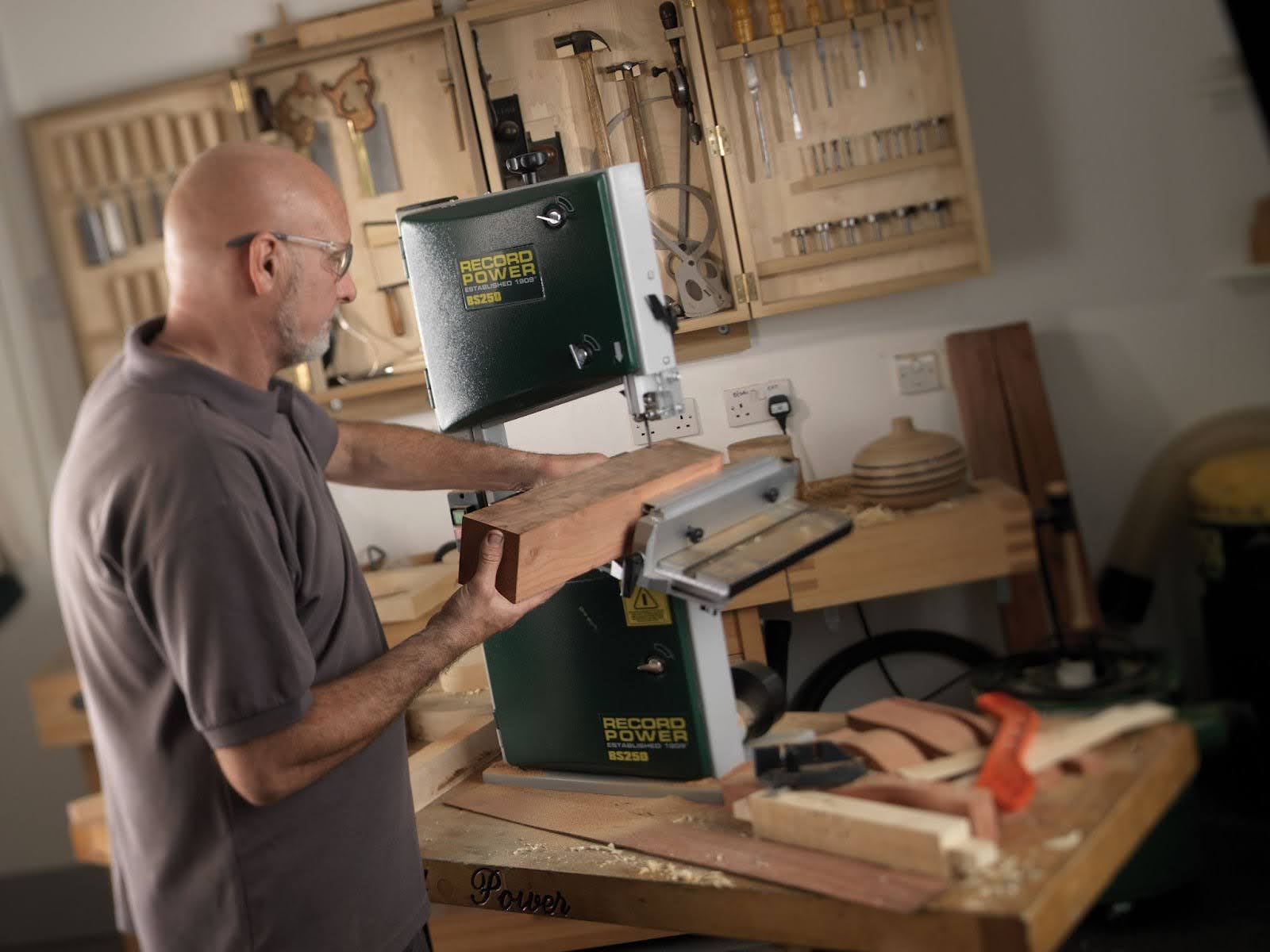 Mann arbeitet mit Bandsäge